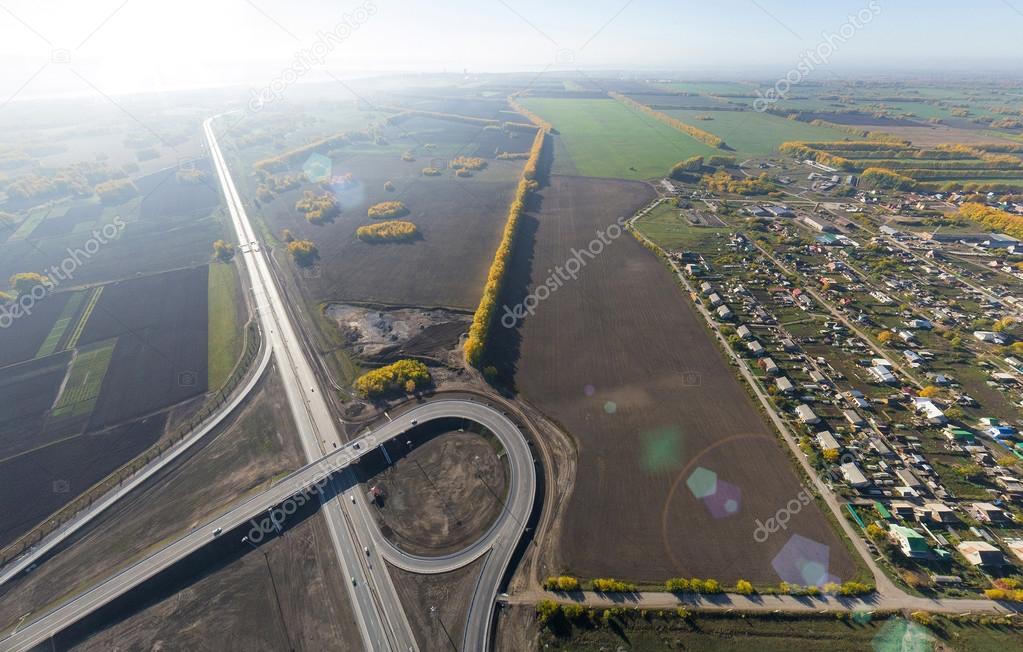 Aerial road interchange, viaduct. Crossroads view parking lots, bridges. Copter shot. Panoramic image.
