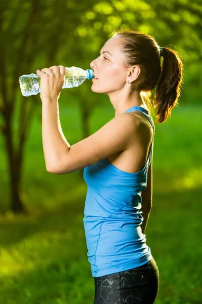 Young woman drinking water after fitness exercise — Stock Photo, Image