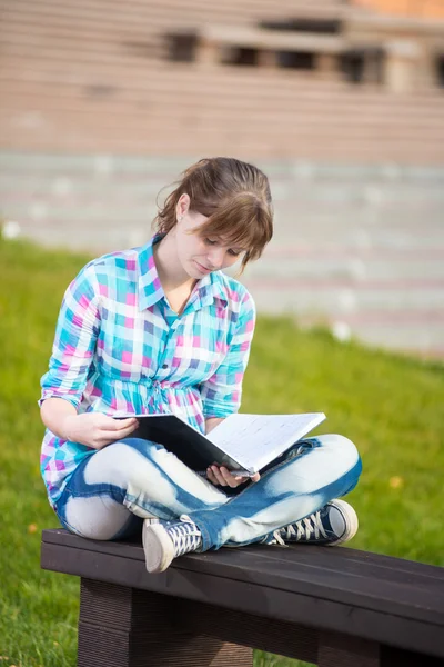 Estudiante con cuaderno en el banquillo. Parque del campus de verano . —  Fotos de Stock