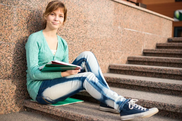 Girl sitting on stairs and reading note — Stock Photo, Image