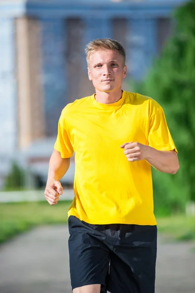 Sportig man jogga i gatan stadsparken. Utomhus fitness. — Stockfoto