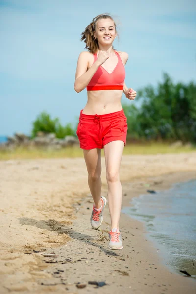 Giovane signora che corre alla soleggiata spiaggia di sabbia estiva. Allenati. Jogging — Foto Stock