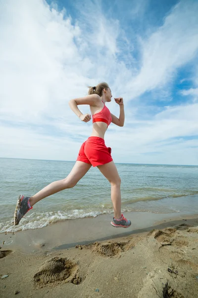 Νεαρή κοπέλα που τρέχει στην παραλία άμμου ηλιόλουστο καλοκαίρι. Προπόνηση. Σπρώχνω — Φωτογραφία Αρχείου
