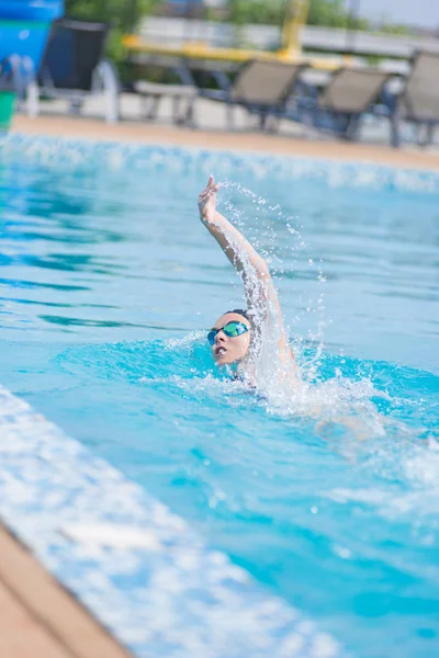 Frau in Schutzbrille schwimmt im Crawl-Stil — Stockfoto