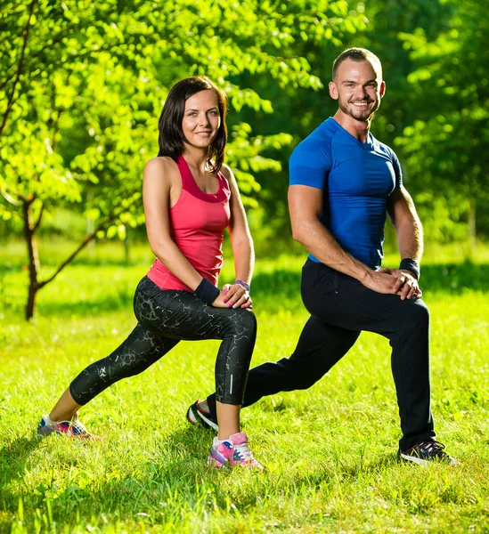 Erkek ve kadın esneme egzersizleri yapıyor. — Stok fotoğraf