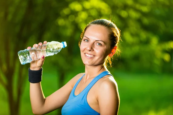 Young woman drinking water after fitness exercise — Stock Photo, Image