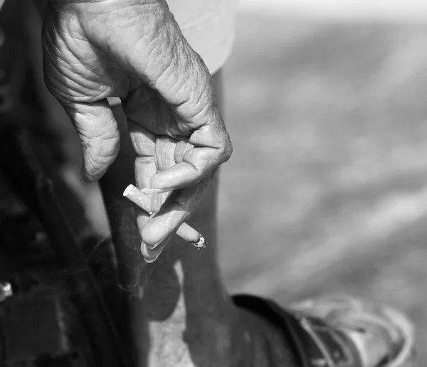 Older man holds cigarette in monochrome — Stock Photo, Image