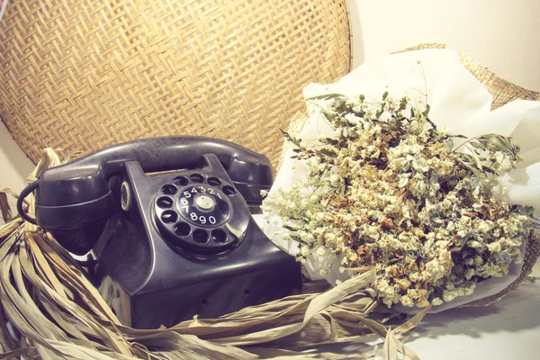 Натюрморт с ретро-телефоном, мертвые цветы, тонированное изображение — стоковое фото