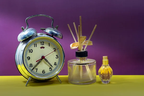 Still life with broken alarm clock, empty essential oil, classic — Stock Photo, Image