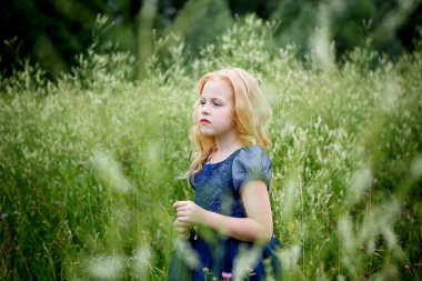 Mavi elbiseli güzel küçük kız portresi