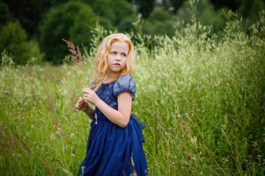 Mavi elbiseli güzel küçük kız portresi