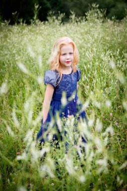 Mavi elbiseli güzel küçük kız portresi