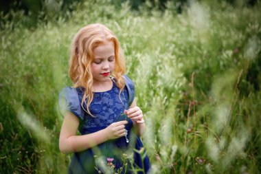 Mavi elbiseli güzel küçük kız portresi