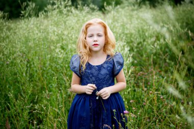 Mavi elbiseli güzel küçük kız portresi