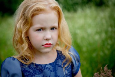 Mavi elbiseli güzel küçük kız portresi