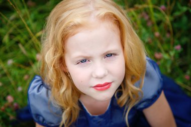 Mavi elbiseli güzel küçük kız portresi