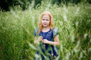 Mavi elbiseli güzel küçük kız portresi