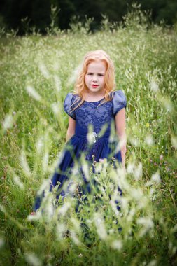 Mavi elbiseli güzel küçük kız portresi