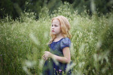 Mavi elbiseli güzel küçük kız portresi