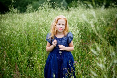 Mavi elbiseli güzel küçük kız portresi