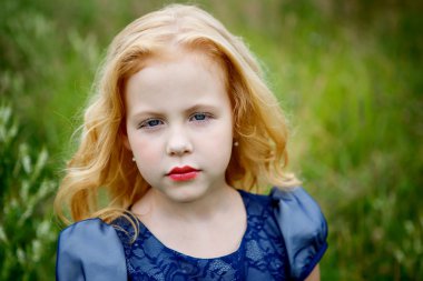 Mavi elbiseli güzel küçük kız portresi