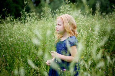 Mavi elbiseli güzel küçük kız portresi