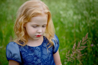 Mavi elbiseli güzel küçük kız portresi