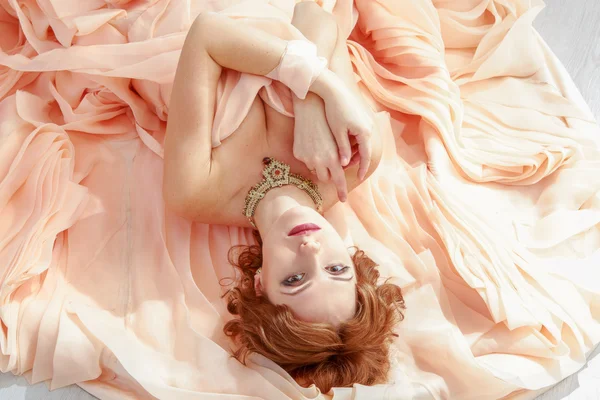 Porträtt av en vacker flicka i en beige peach klä — Stockfoto