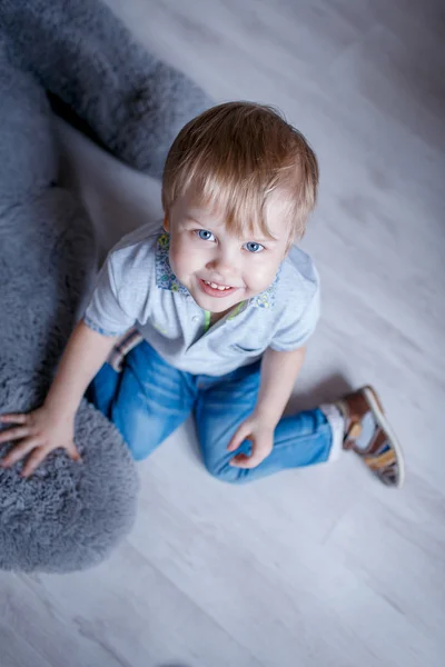 Retrato de menino com um grande urso de brinquedo no estúdio — Fotografia de Stock