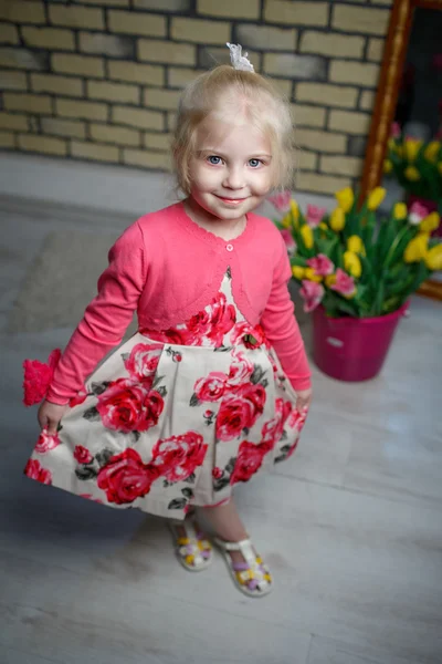 Portret van een mooi klein meisje met bloemen — Stockfoto