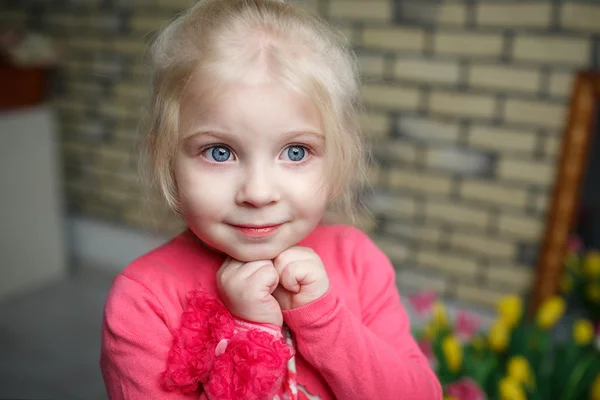 Portret van een mooi klein meisje met bloemen — Stockfoto