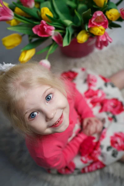 Portret van een mooi klein meisje met bloemen — Stockfoto