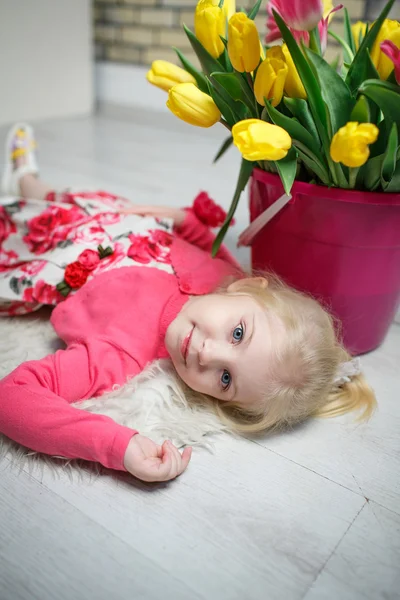 Portret van een mooi klein meisje met bloemen — Stockfoto