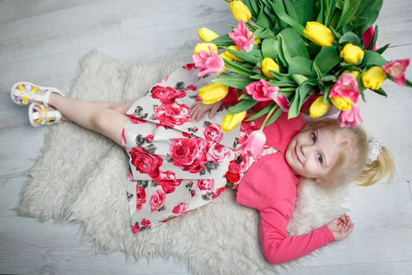 Porträtt av en vacker liten flicka med blommor — Stockfoto