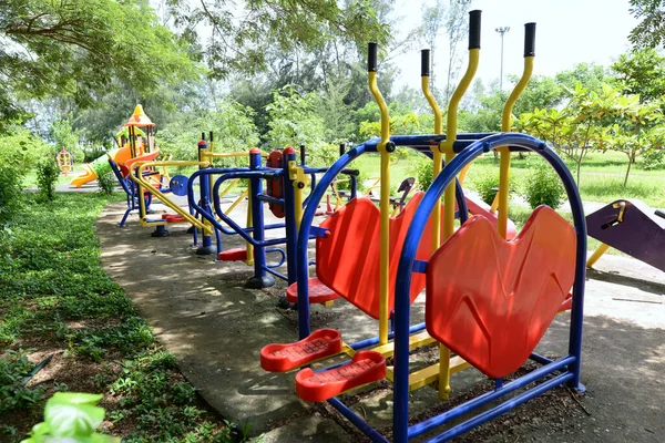 Kleurrijke Outdoor Fitnessapparaten Het Park Zijn Weelderig Veel Groene Bomen — Stockfoto