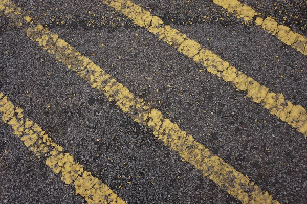 禁止停车的黄色线穿越区域 沥青路面上用于交叉口标志的黄色油漆路标 — 图库照片