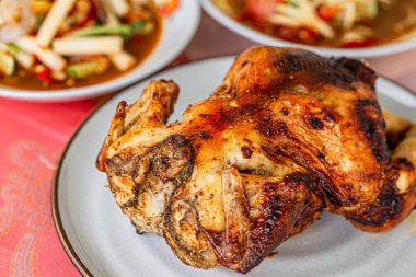 Ahşap masada kızarmış tavuk ve sebze.