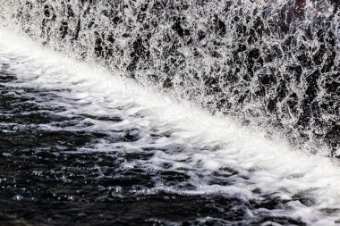 Yapay şelale ve bahçede heykel.