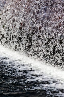 Yapay şelale ve bahçede heykel.