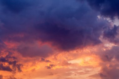 Bulutlu dramatik gökyüzü ve turuncu gün batımı.