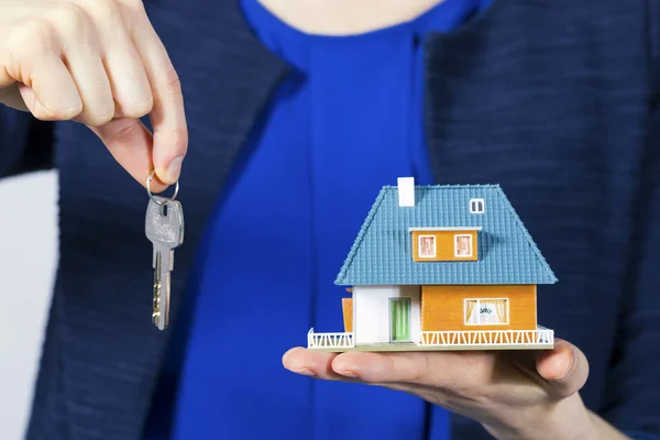 Immobilienmakler mit Schlüssel und Hausmodell zur Hand — Stockfoto