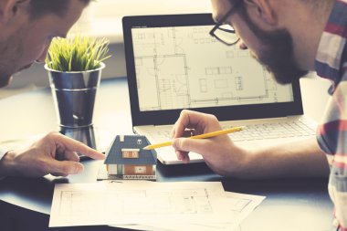 Yeni müstakil ev modeli ofisinde müşteriye gösterilen mimar