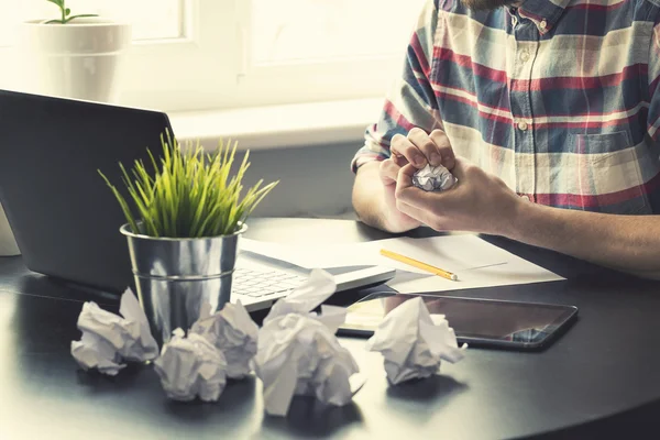 Lugar de trabajo de oficina con muchas bolas de papel arrugadas sobre la mesa —  Fotos de Stock