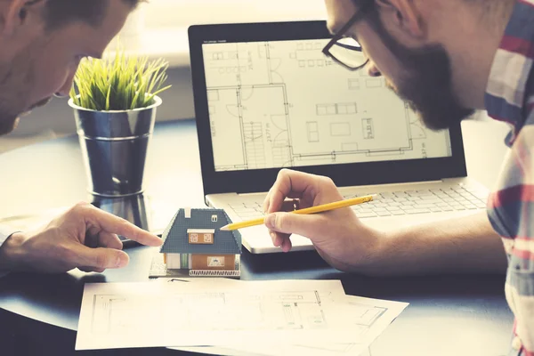 Arquitecto mostrando nuevo modelo de casa familiar al cliente en la oficina —  Fotos de Stock