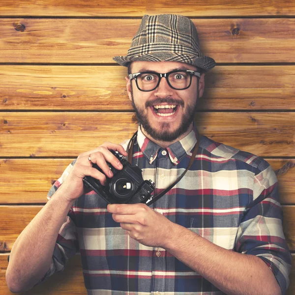 Vintage style happy smiling hipster with retro camera in hands — Stock Photo, Image