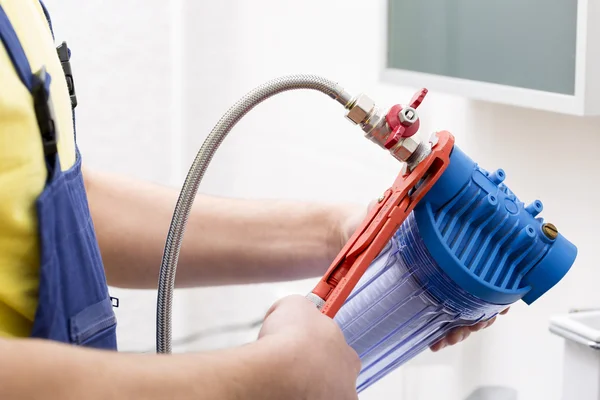 Loodgieter installeren nieuwe waterfilter in badkamer — Stockfoto