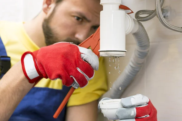 Encanador fixando o sifão pia em um banheiro ou cozinha — Fotografia de Stock