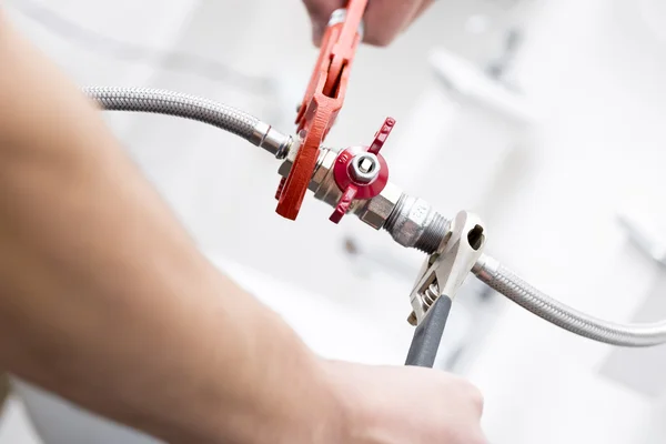 Fontanero atornillar accesorios de plomería en el baño — Foto de Stock