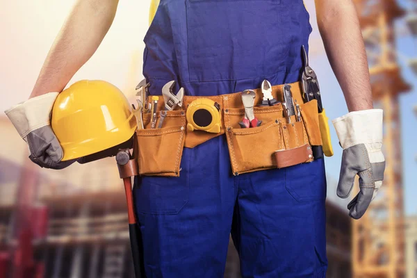 Trabajador de la construcción con correa de herramientas en la obra — Foto de Stock