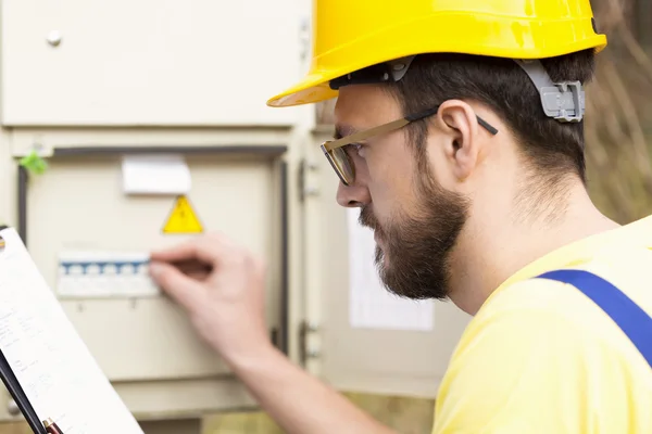 Elektriker checkt Sicherungskasten — Stockfoto